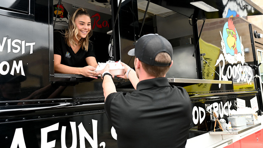 photo of employee handing off food from Roosters food truck